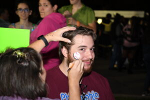 Someone getting face painting done at scream screen